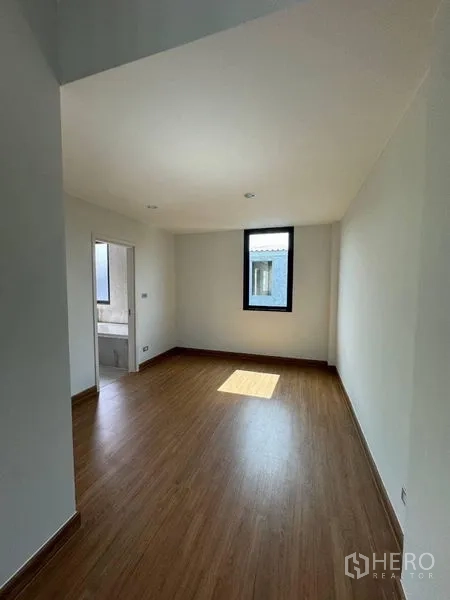 Townhouse for rent - Bedroom with ensuite access and a narrow window, finished in wood floors.