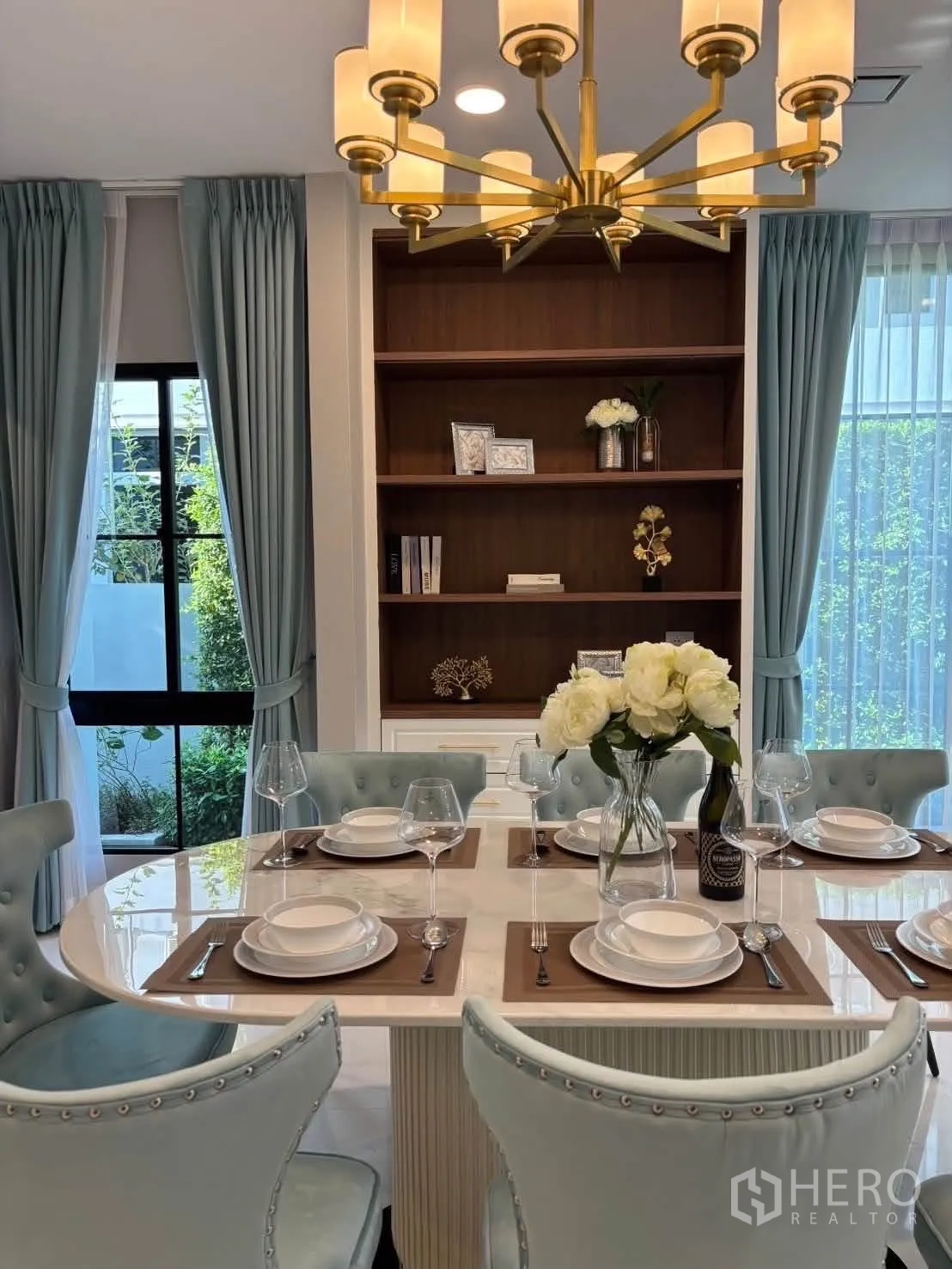 独栋房屋 for rent in Saphan Sung, Bangkok - 餐桌上方金色吊灯，背后内置书架。