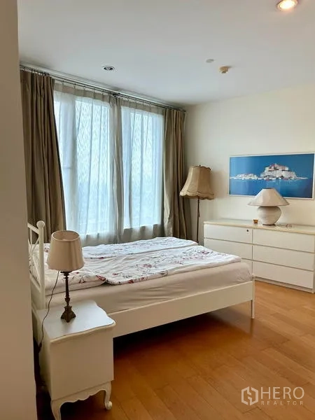 คอนโด ให้เช่า - ห้องนอนรองบรรยากาศอบอุ่น เตียงสีขาว ตู้ลิ้นชัก และผ้าม่านโปร่ง