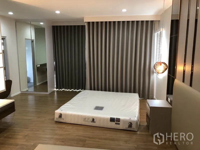 独立式住宅 出租在Prawet, Bangkok - 大主卧，配床垫、遮光窗帘与木地板。