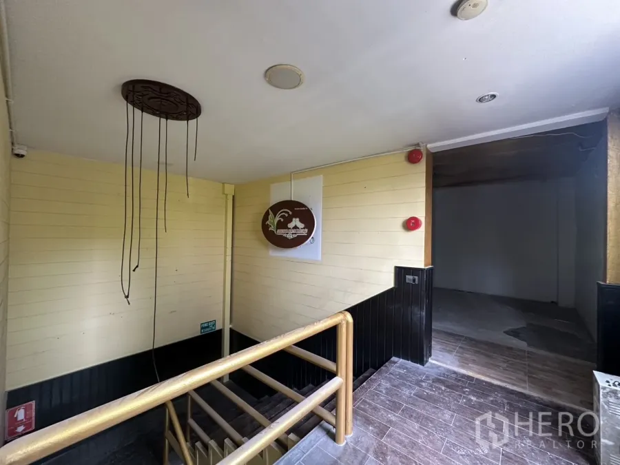 พื้นที่ขายปลีก ให้เช่าในBang Rak, Bangkok - โถงบันไดขึ้นสู่พื้นที่ร้านค้าแบบห้องเปล่าพร้อมราวไม้และอุปกรณ์ความปลอดภัย