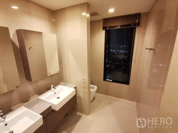 คอนโด ให้เช่าหรือขายในDin Daeng, Bangkok - ห้องน้ำกว้าง อ่างล้างหน้าแบบคู่ พร้อมหน้าต่างมองเห็นวิวเมืองยามค่ำคืน