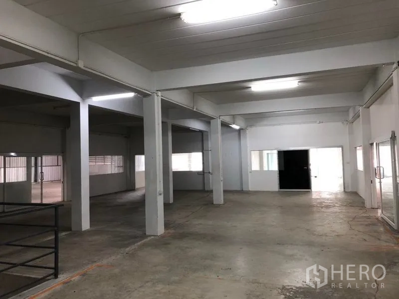 คลังสินค้า ให้เช่าในKhlong Sam Wa, Bangkok - พื้นที่โกดังโล่ง พื้นคอนกรีต เสาโครงสร้างสีขาว และไฟแสงสว่างแบบหลอดยาว