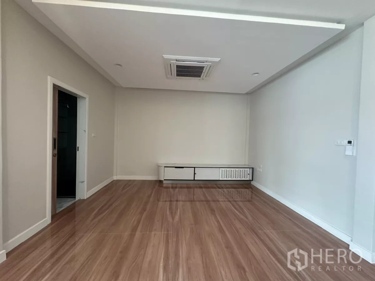 联排别墅 出租在Watthana, Bangkok - 空房，亮光木地板与矮电视柜。