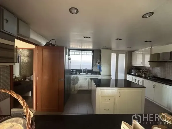 Home Office for sale in Lam Luk Ka, Pathum Thani - Spacious white kitchen with black granite island, ample cabinetry, window and tiled floor
