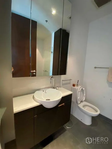 Condominium for rent in Yan Nawa, Bangkok - Contemporary bathroom with mirrored vanity cabinets and toilet.