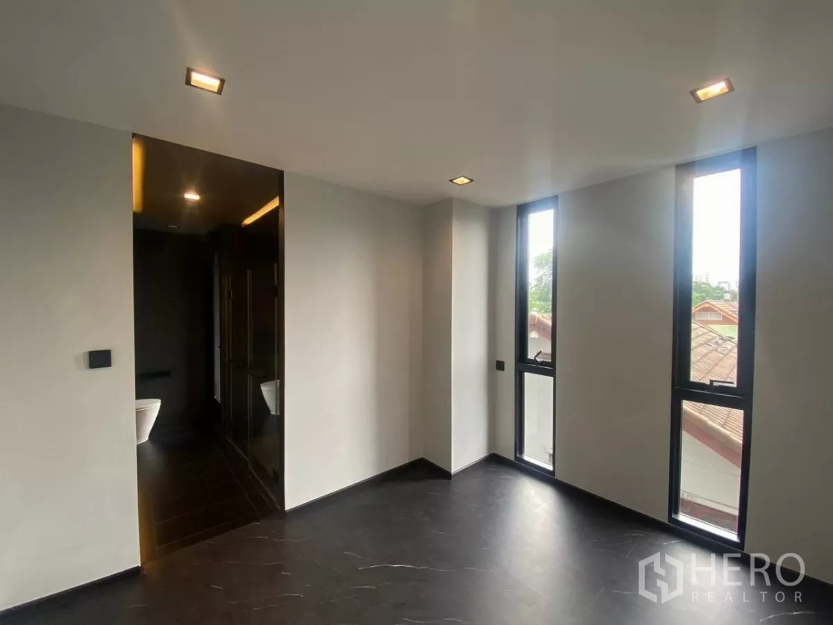 ทาวน์เฮาส์ ให้เช่าในHuai Khwang, Bangkok - ห้องนอนติดห้องน้ำในตัว พร้อมหน้าต่างสูงแคบสามบาน.