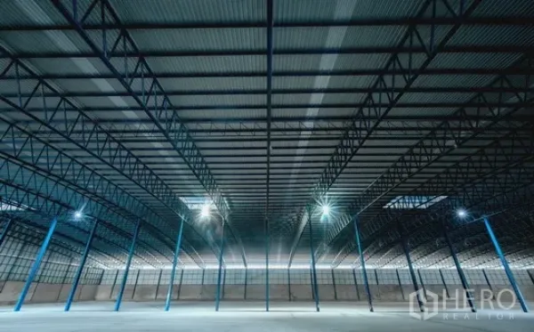 Warehouse for rent in Pathum Thani - Ceiling view of steel trusses and skylights illuminating the spacious warehouse.