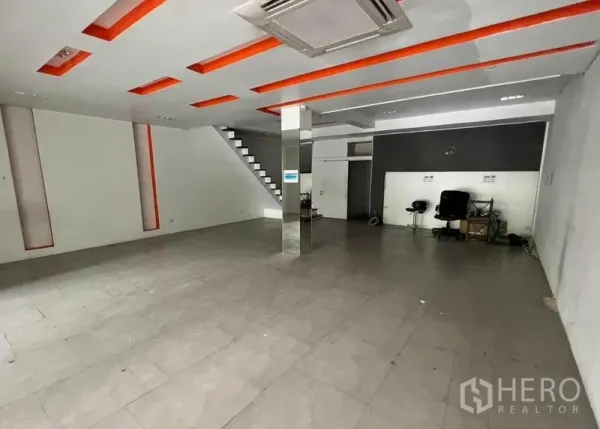 店屋 出租在Watthana, Bangkok - 宽敞零售区，镜面立柱、嵌灯天花、瓷砖地面与楼梯通达。