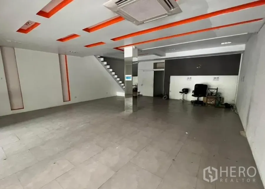 店屋 出租在Watthana, Bangkok - 宽敞零售区，镜面立柱、嵌灯天花、瓷砖地面与楼梯通达。