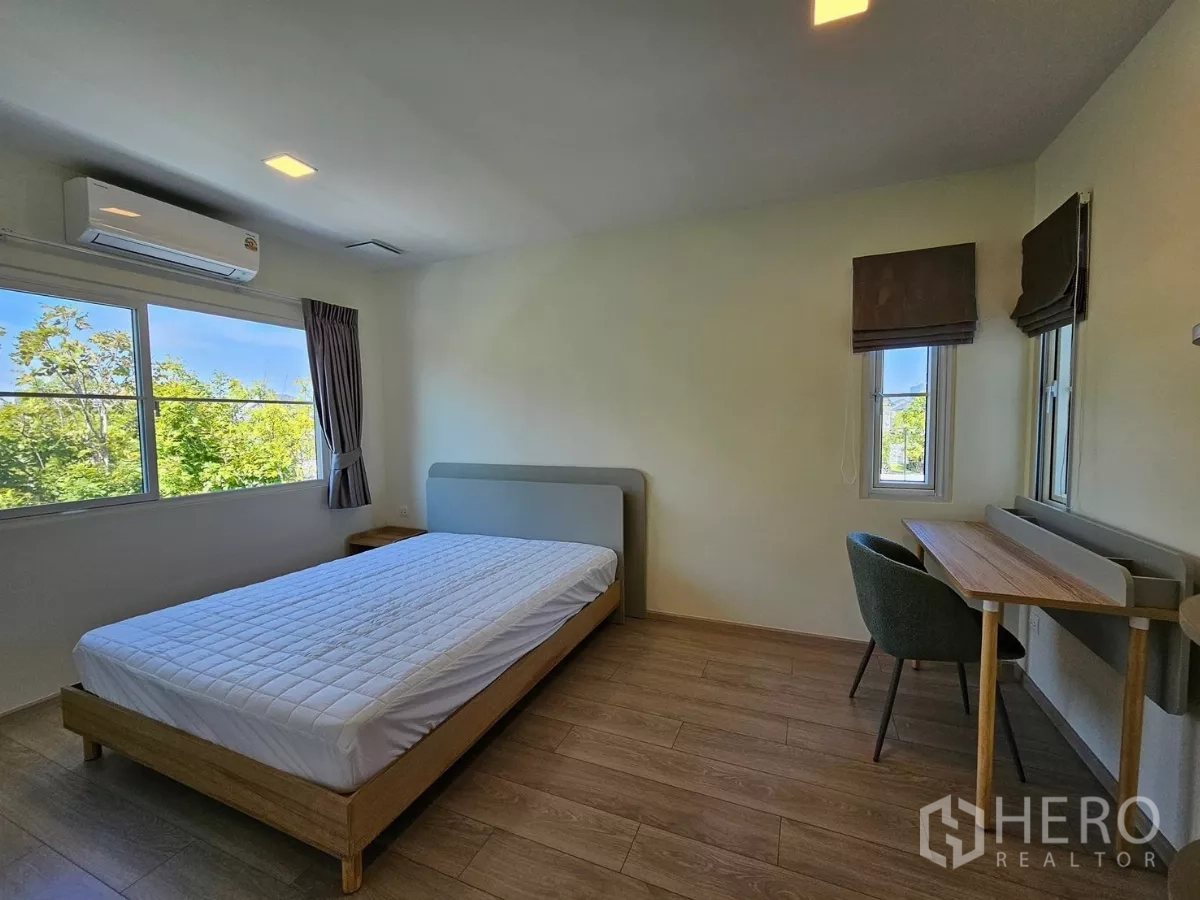 Detached House for rent in Bang Phli, Samut Prakan - Bright bedroom with double bed, study desk and green views.