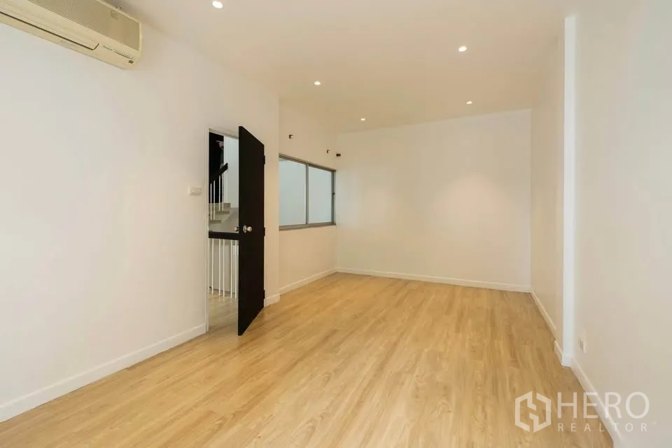 联排别墅 出租在Khlong Toei, Bangkok - 大卧室，木地板、壁挂空调，门通向楼梯间。