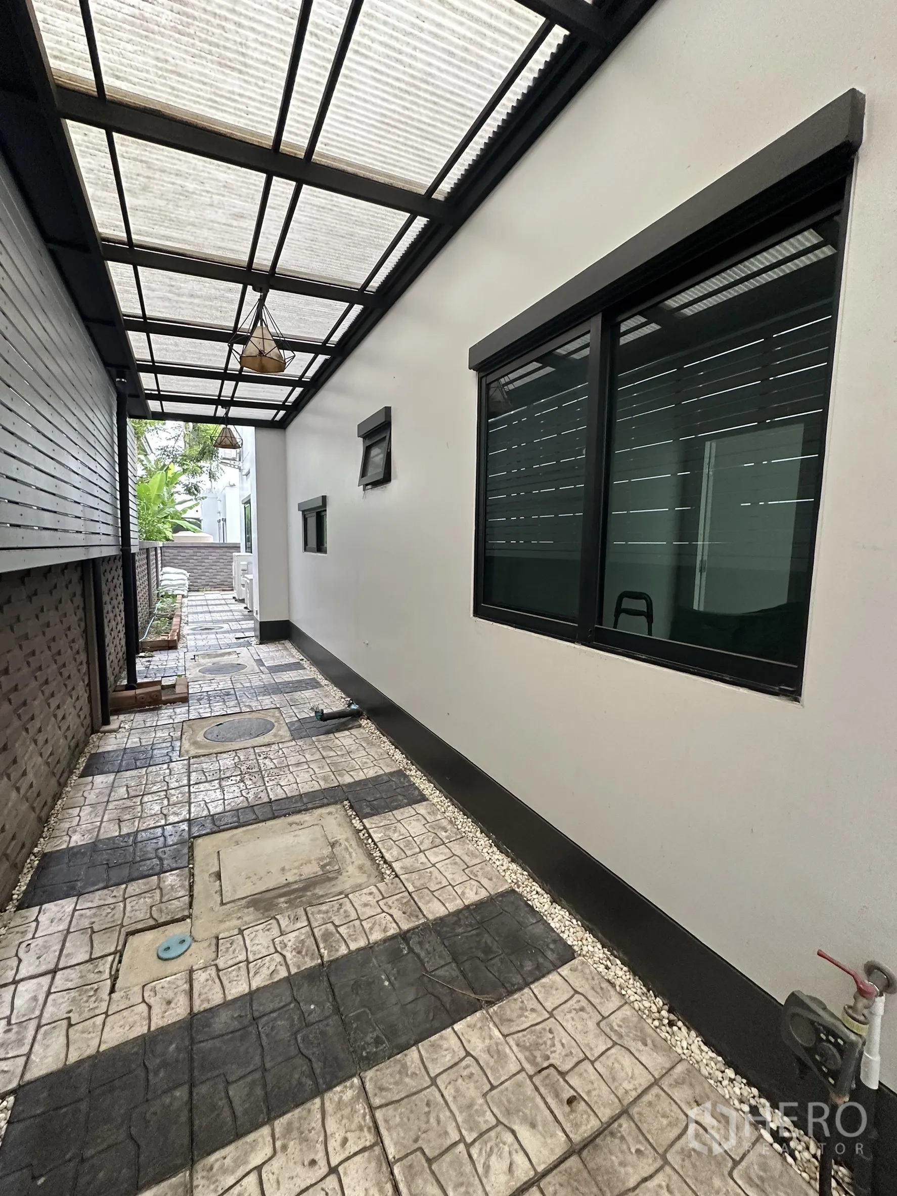 บ้าน ให้เช่าในLam Luk Ka, Pathum Thani - ทางเดินข้างบ้านมีหลังคาโปร่งแสง พื้นทางเดินบล็อก