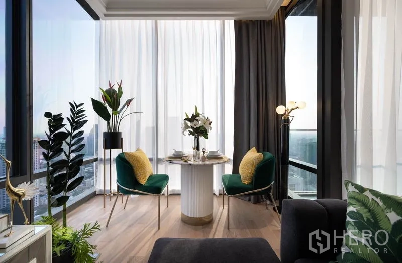 公寓 出租在Bang Rak, Bangkok - 双人餐桌位于转角落地窗旁，享受全景城市视野与绿植。