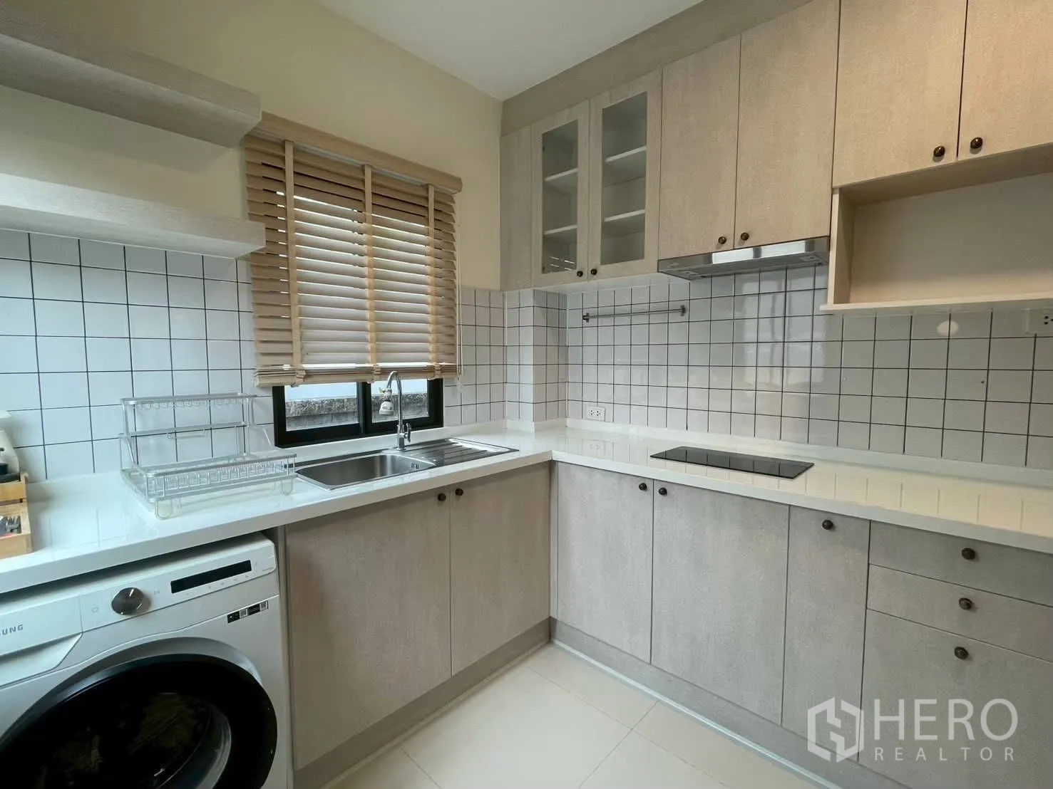 Detached House for rent in Bang Phli, Samut Prakan - Modern L-shaped kitchen with hob, hood, double sink and washing machine.