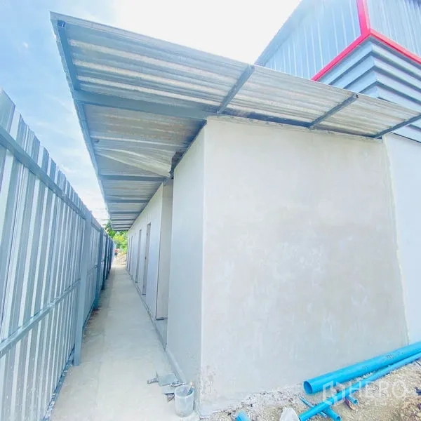 คลังสินค้า ให้เช่าในBang Khae, Bangkok - อาคารบริการด้านข้าง มีหลังคากันสาดและทางเดิน พร้อมท่อสาธารณูปโภคสีฟ้า