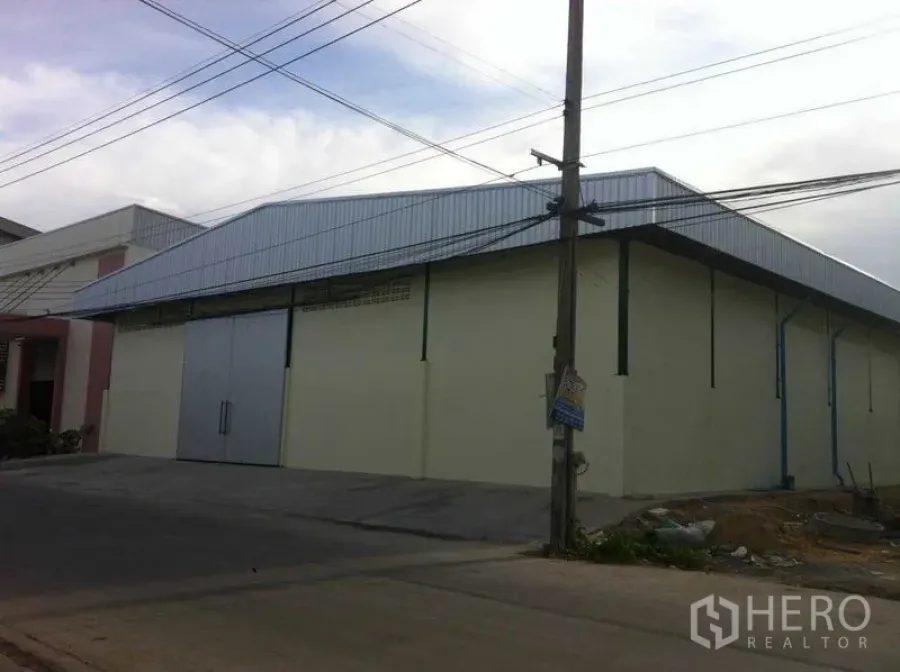 คลังสินค้า ให้เช่าในBang Phli, Samut Prakan - มุมมองภายนอกโกดัง แสดงทางรถกว้าง สายสาธารณูปโภค และหลังคาเมทัลชีท