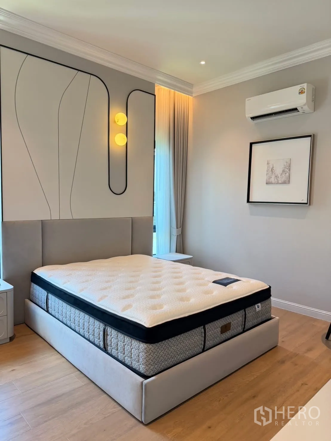Detached House for rent in Saphan Sung, Bangkok - Cozy bedroom with padded headboard, modern wall sconce, AC, and large bed.