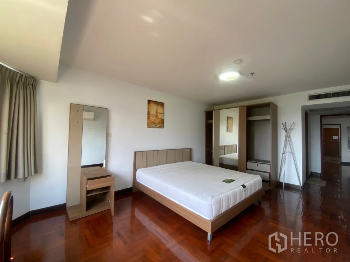 Condominium for rent in Watthana, Bangkok - Spacious bedroom with double bed, wardrobe and vanity on glossy wood flooring.