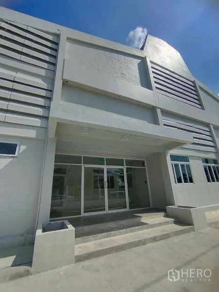 Warehouse for rent in Bang Pakong, Chachoengsao - Main entrance of the warehouse with glass doors, canopy and steps.