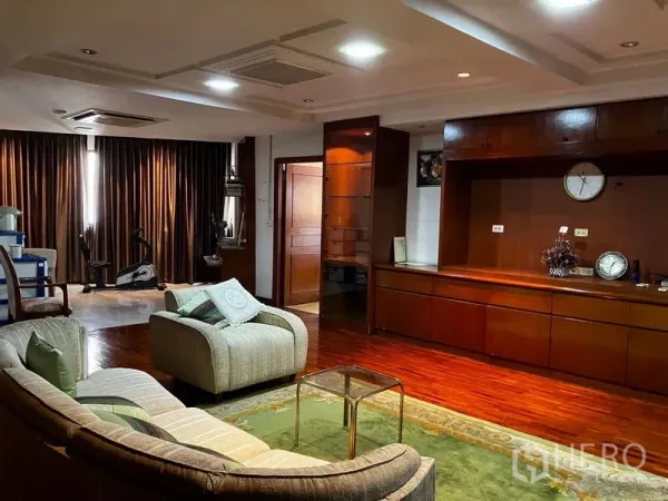 คอนโด ให้เช่าหรือขายในKhlong Toei, Bangkok - โซฟาทรงโค้งหันเข้าตู้บิลท์อินไม้ยาว พร้อมพรมและผ้าม่านทึบ ในห้องนั่งเล่นใหญ่