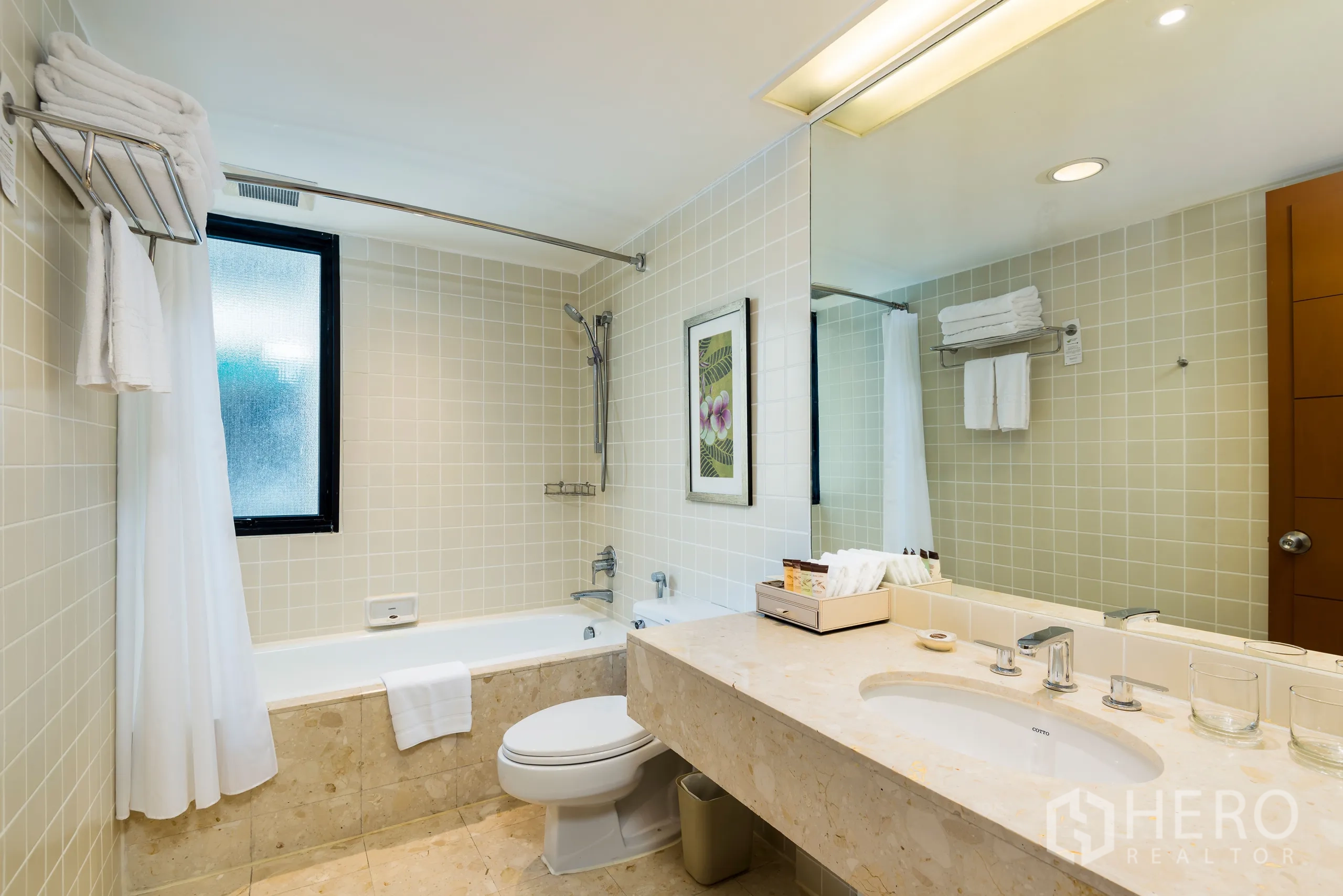 Condominium for rent in Yan Nawa, Bangkok - Second bathroom with bathtub, toilet, large mirror and beige tiled walls.