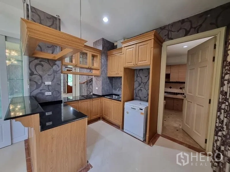 บ้าน ให้เช่าในYan Nawa, Bangkok - แพนทรี่ครัวบิวท์อินไม้ ท็อปหินแกรนิตสีดำ มีชั้นห้อยและทางเข้าครัวไทย