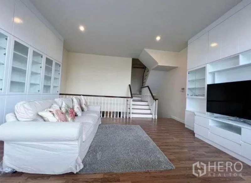 ทาวน์เฮาส์ ให้เช่าในPhra Khanong, Bangkok - เลานจ์ชั้นบนพร้อมโซฟาสีขาว ตู้บิวท์อินเต็มผนัง ชุดชั้นวางทีวีและบันได