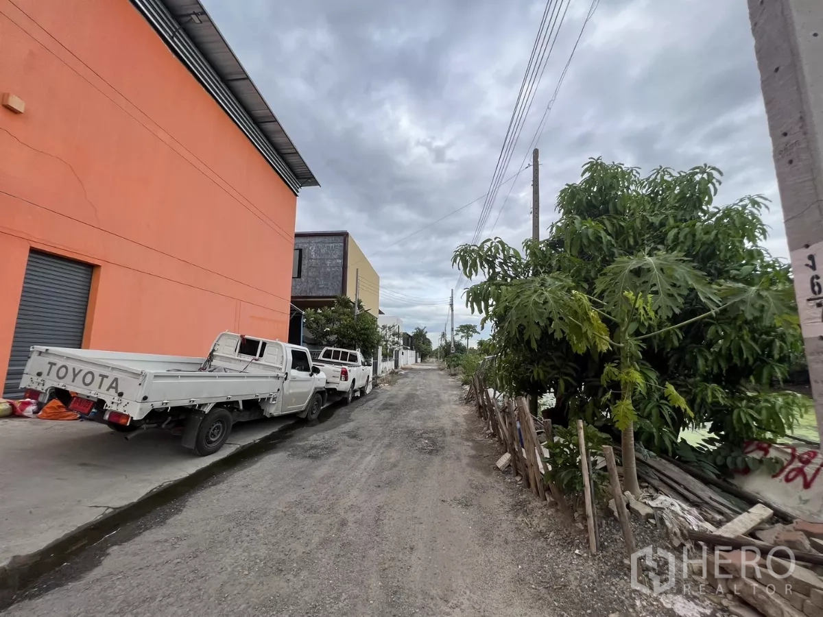 คลังสินค้า ให้เช่าหรือขายในLat Krabang, Bangkok - ถนนลูกรังหน้าโกดัง มีเสาไฟและต้นไม้ เข้าออกสะดวกสำหรับรถบรรทุก