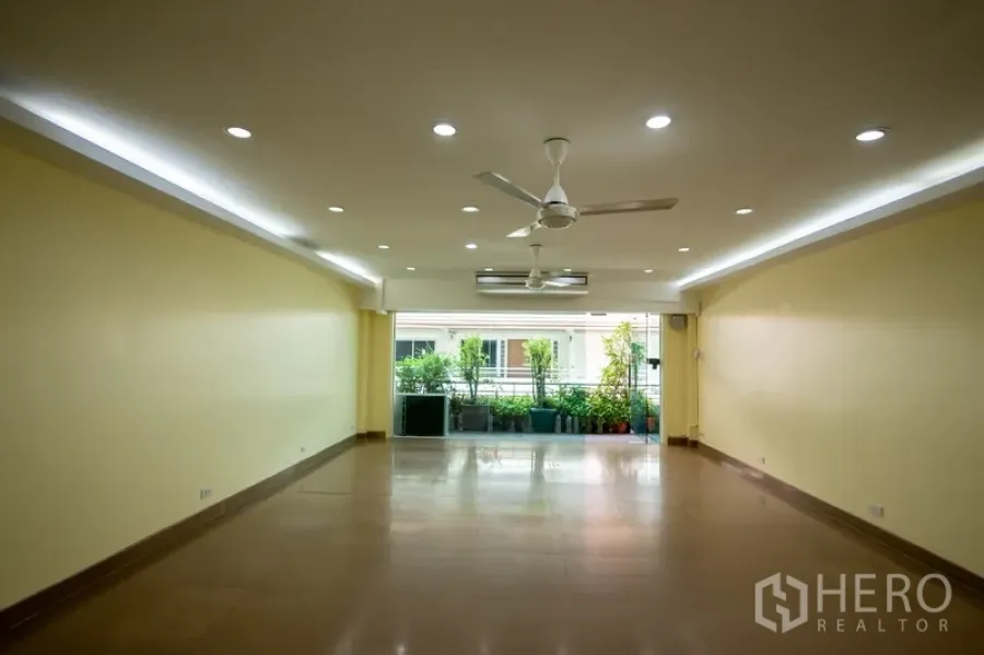 สำนักงานที่บ้าน ให้เช่า - ห้องโถงโล่งกว้าง เพดานฝังไฟ พัดลมเพดาน และประตูกระจกออกสู่ระเบียงมีต้นไม้กระถาง