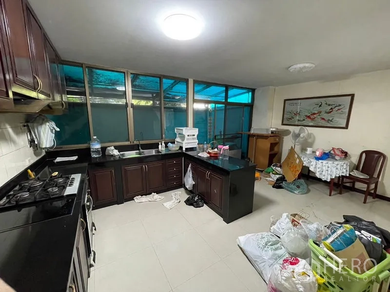 สำนักงานที่บ้าน ให้เช่าในWatthana, Bangkok - ครัวรูปตัวแอล ตู้ไม้สีเข้ม เคาน์เตอร์หินสีดำ และหน้าต่างบานใหญ่