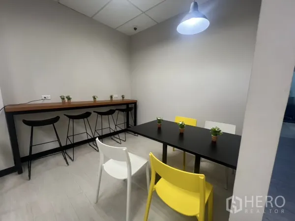 Office Space for rent in Huai Khwang, Bangkok - Breakout lounge with bar counter and stools, dining table, pendant light and potted plants.