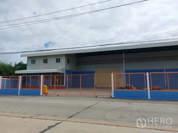 工厂 出租在Lat Lum Kaeo, Pathum Thani - 工厂外观，蓝橙色围栏与宽阔大门，出入便捷。
