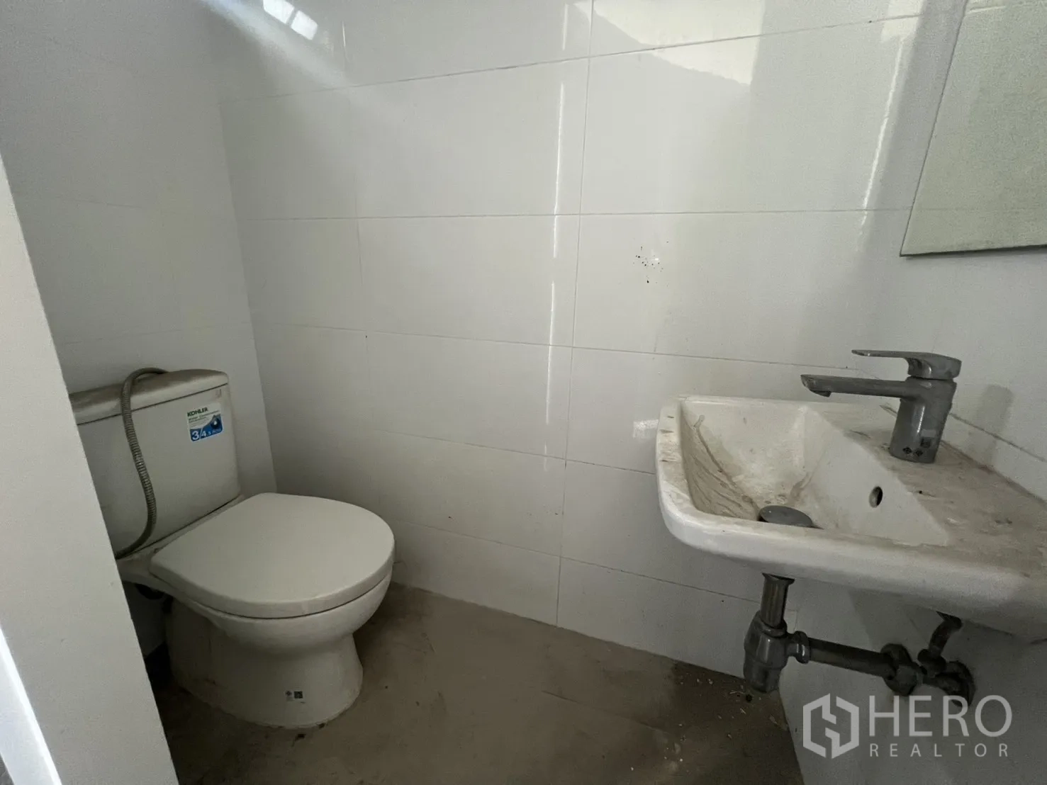 พื้นที่ขายปลีก ให้เช่า - ห้องน้ำพื้นฐานพร้อมโถสุขภัณฑ์และอ่างล้างหน้า ตกแต่งกระเบื้องผนังสีขาว