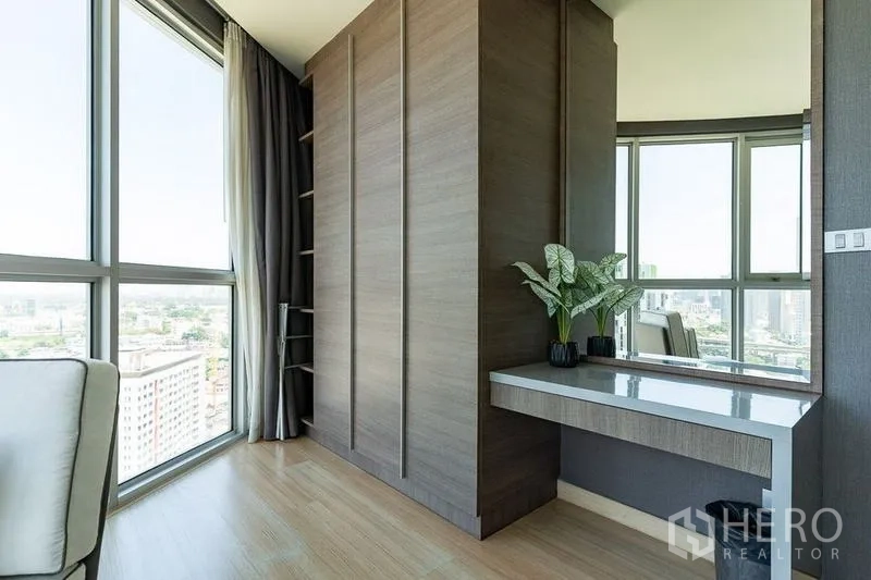 Condominium for rent - Built-in wardrobe with dressing table and mirror next to large corner windows.