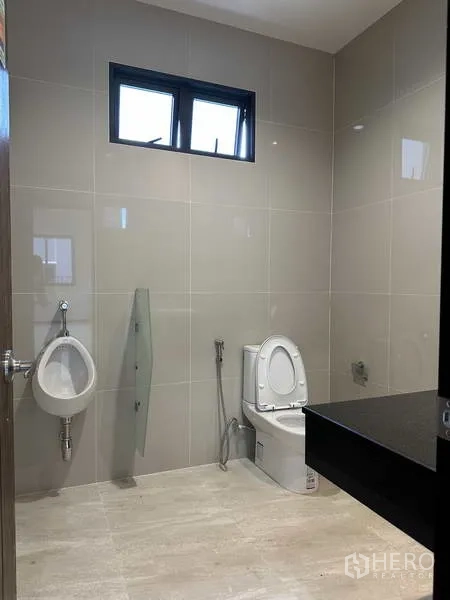 โรงงาน ให้เช่าหรือขายในLam Luk Ka, Pathum Thani - ห้องสุขาพร้อมโถส้วม โถปัสสาวะ หน้าต่าง และเคาน์เตอร์ดำ