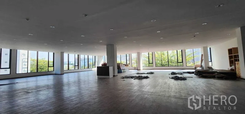 办公空间 出租在Khlong San, Bangkok - 转角楼层，落地窗环绕与开阔空间及柱体。