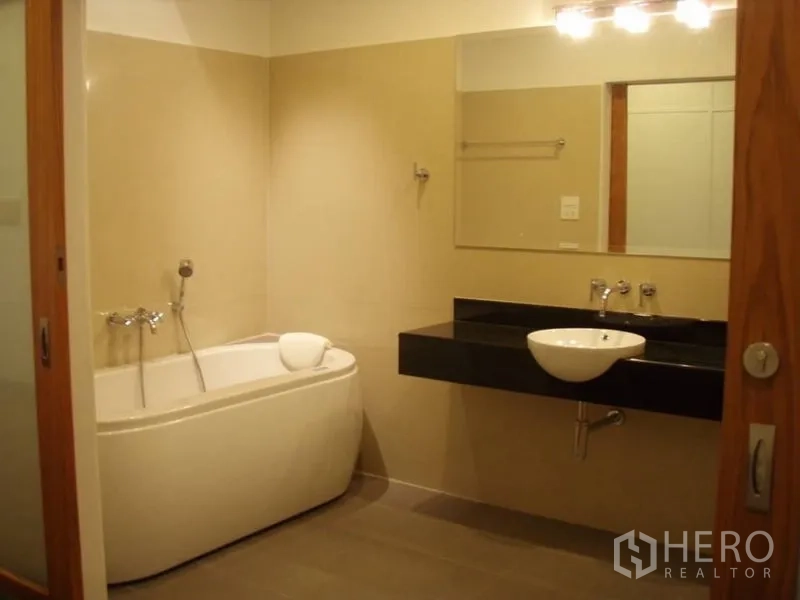 บ้าน ให้เช่าในHuai Khwang, Bangkok - ห้องน้ำสไตล์โมเดิร์น มีอ่างอาบน้ำ เคาน์เตอร์ท็อปสีดำ อ่างล้างหน้าและกระจกบานใหญ่