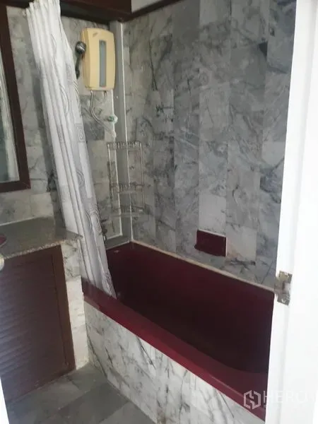Condominium for rent in Watthana, Bangkok - Bathroom with marble tiles, a bathtub, and shower heater.