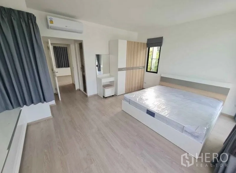 ทาวน์เฮาส์ ให้เช่าในBang Phli, Samut Prakan - อีกมุมของห้องนอนโปร่ง เตียง ตู้เสื้อผ้า กระจกเงา และเครื่องปรับอากาศ