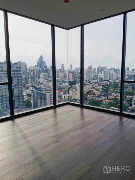 Condominium for rent in Watthana, Bangkok - Corner room with wraparound floor-to-ceiling glass showcasing Bangkok skyline views.