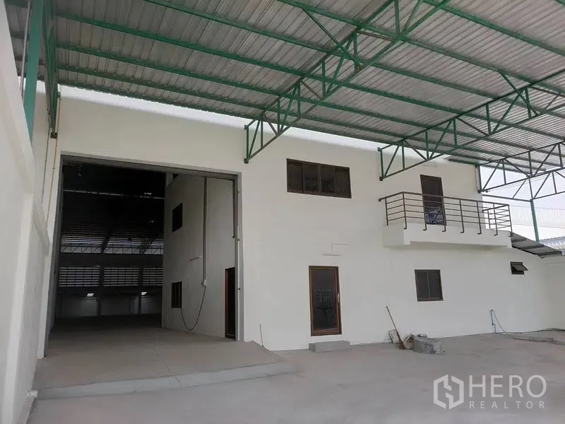 Factory for rent or sale in Bang Phli, Samut Prakan - Covered loading bay with roller shutter and attached two-storey office block.