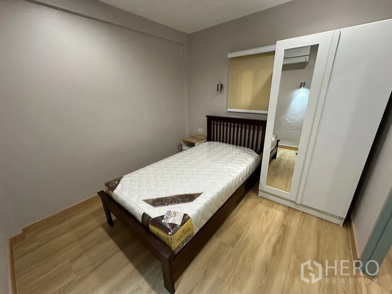 ทาวน์เฮาส์ ให้เช่าในPhra Khanong, Bangkok - ห้องนอนขนาดกะทัดรัด เตียงเดี่ยว โต๊ะข้างเตียง และตู้เสื้อผ้าบานกระจก