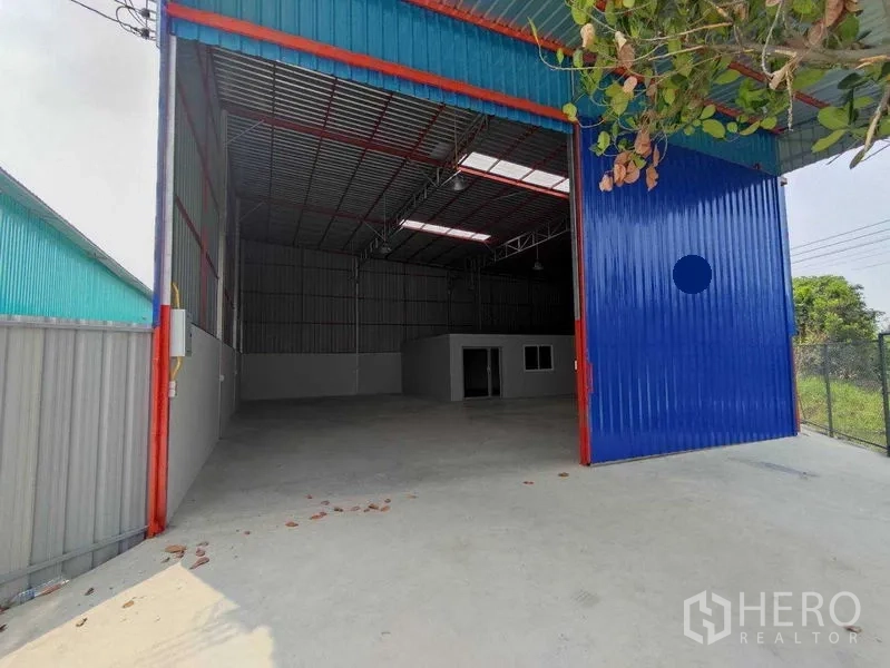 คลังสินค้า ให้เช่าในPak Kret, Nonthaburi - โกดังเพดานสูง ประตูสไลด์สีฟ้าขนาดใหญ่ พร้อมลานคอนกรีตและออฟฟิศภายใน