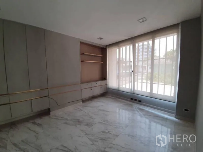 Office Space for rent in Khlong Toei, Bangkok - Private office with built-in shelves, cabinets and sheer blinds over tall windows.