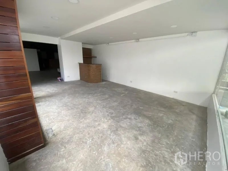 零售空间 出租在Bangkok - 开放零售空间，白墙、筒灯照明，后侧设木质风接待台。