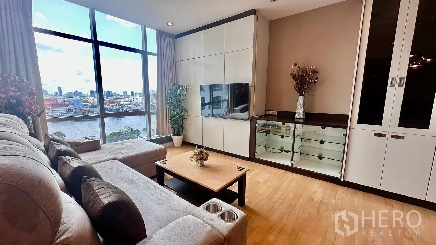 公寓 for rent in Khlong San, Bangkok - 客厅设壁挂电视与内置柜体，巨窗呈现河景全貌。