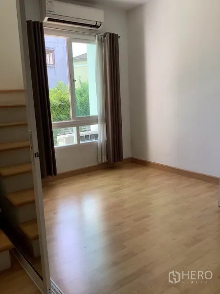 联排别墅 出租或出售在Wang Thonglang, Bangkok - 卧室铺浅木地板，带窗与窗帘，墙装空调，靠近楼梯。
