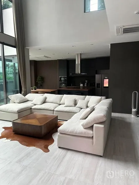 บ้าน ให้เช่าในSaphan Sung, Bangkok - ห้องนั่งเล่นเพดานสูงสองชั้น พร้อมโซฟาสีขาวและครัวด้านหลัง