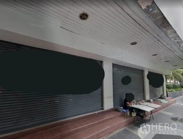 Office Space for rent in Bang Rak, Bangkok - Street-front building with multiple metal roller shutters and a covered sidewalk in Silom’s business area.